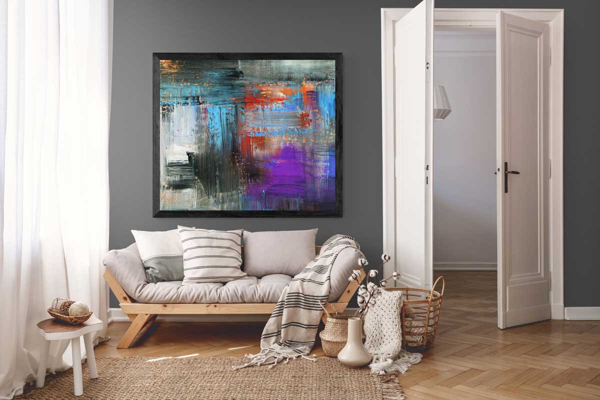 A framed print hung above a sofa in a warmly lit living room, shown at a plausible domestic scale.